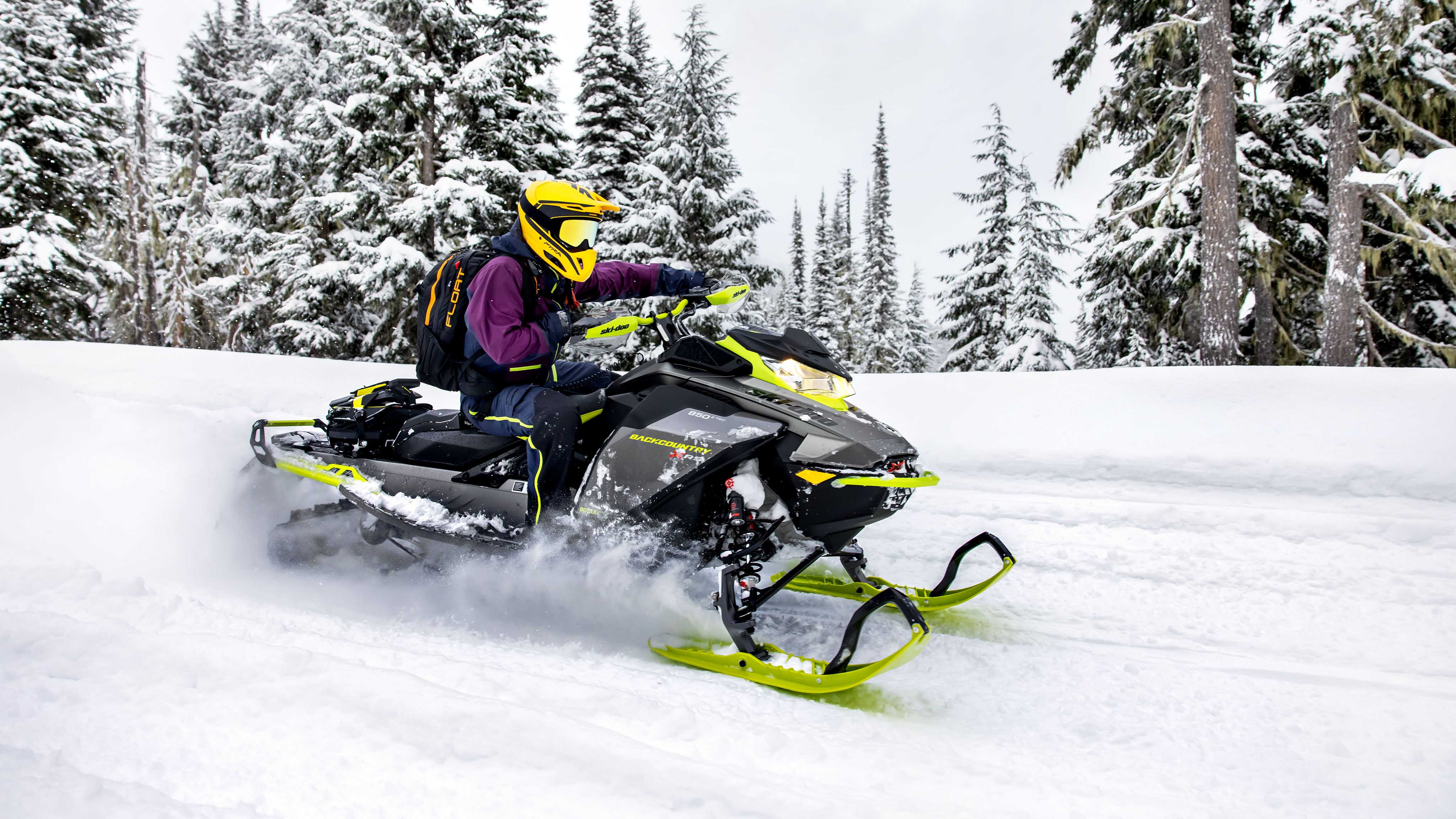 2023 Ski-Doo Backcountry ile bir patikada kar motosikleti yapan kadın