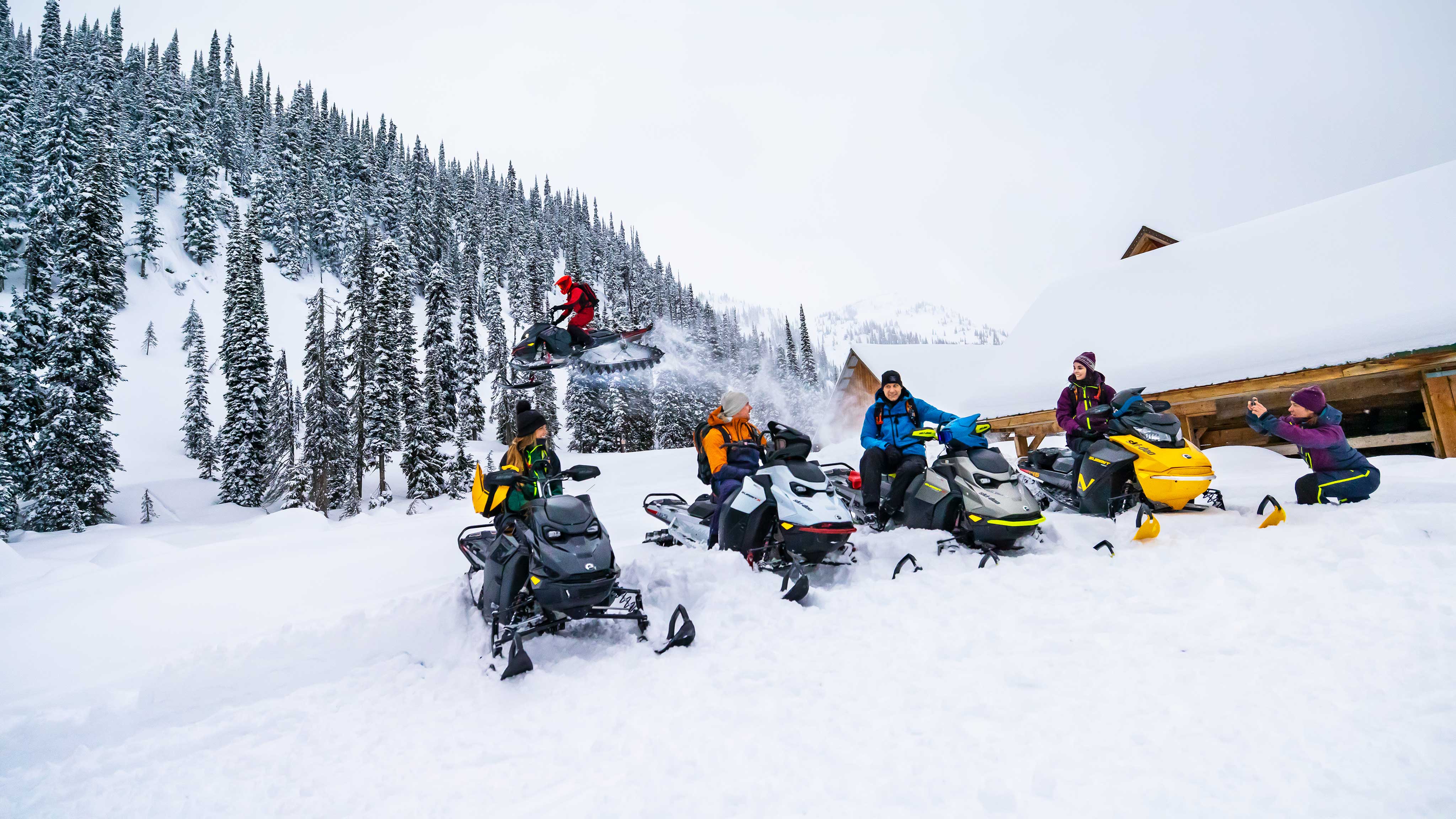 Grupa znajomych podczas jeżdżenia na skuterach śnieżnych Ski-Doo