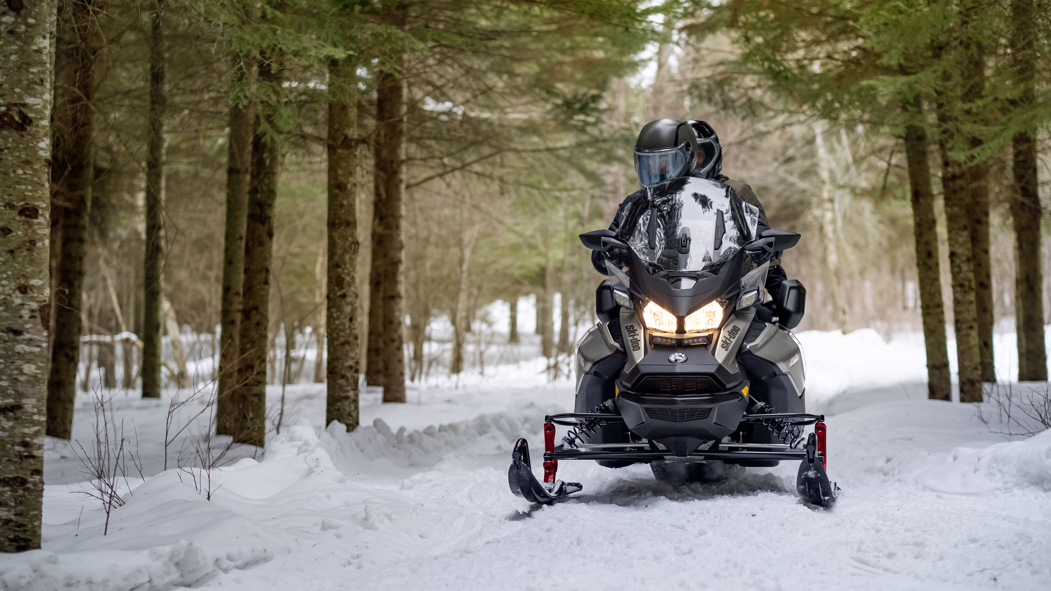 Karda bir çift  2022 Ski-Doo Grand Touring'i kullanıyor.