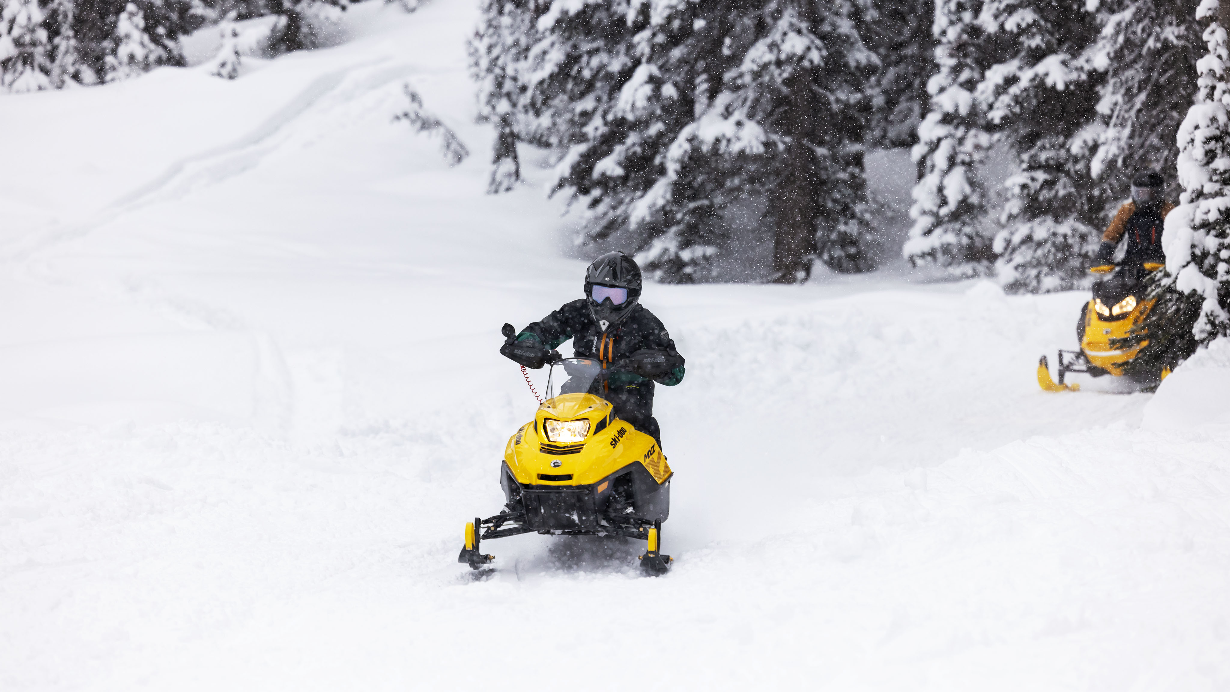 Genç kar motosikleti Ski-Doo MXZ üzerindeki genç sürücü