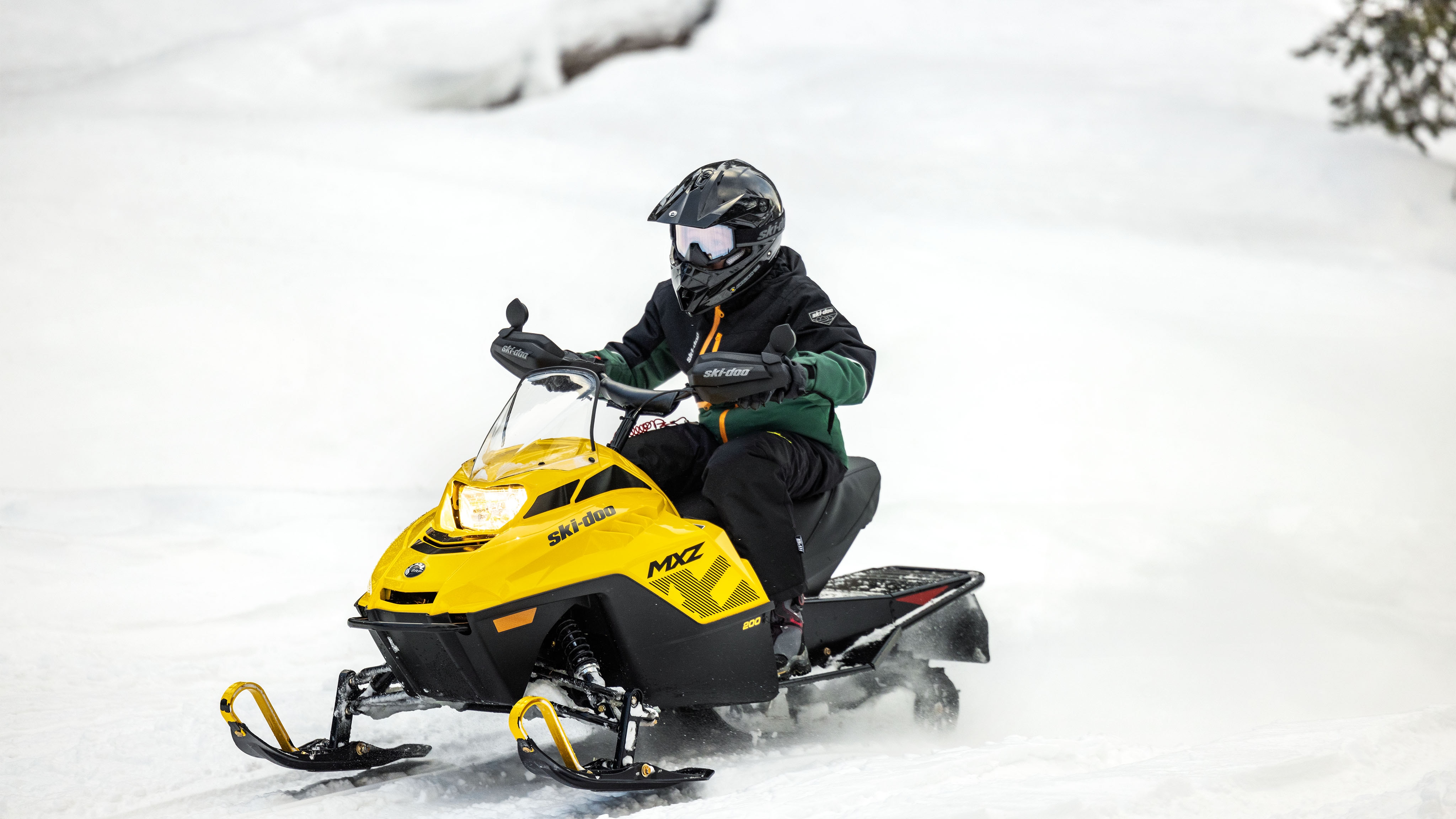 Млад возач на својата Ski-Doo MXZ 200 моторна санка за деца