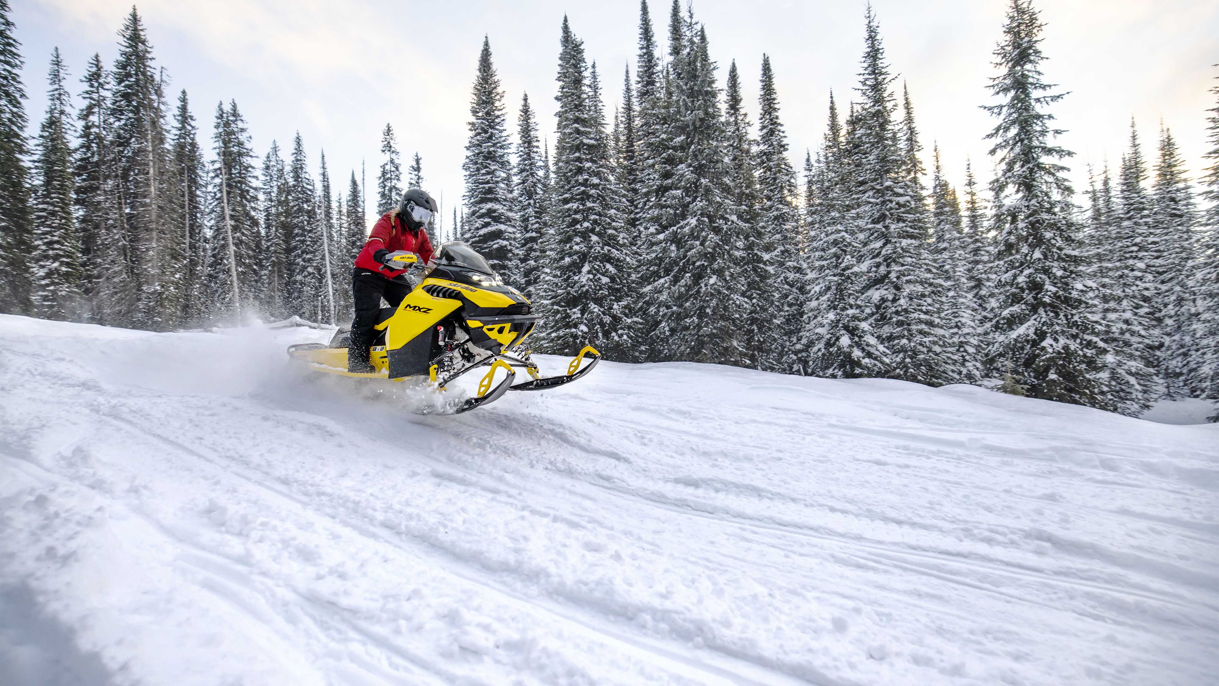 Woman snowmobiling on a snowmobile trail with the 2023 Ski-Doo MXZ