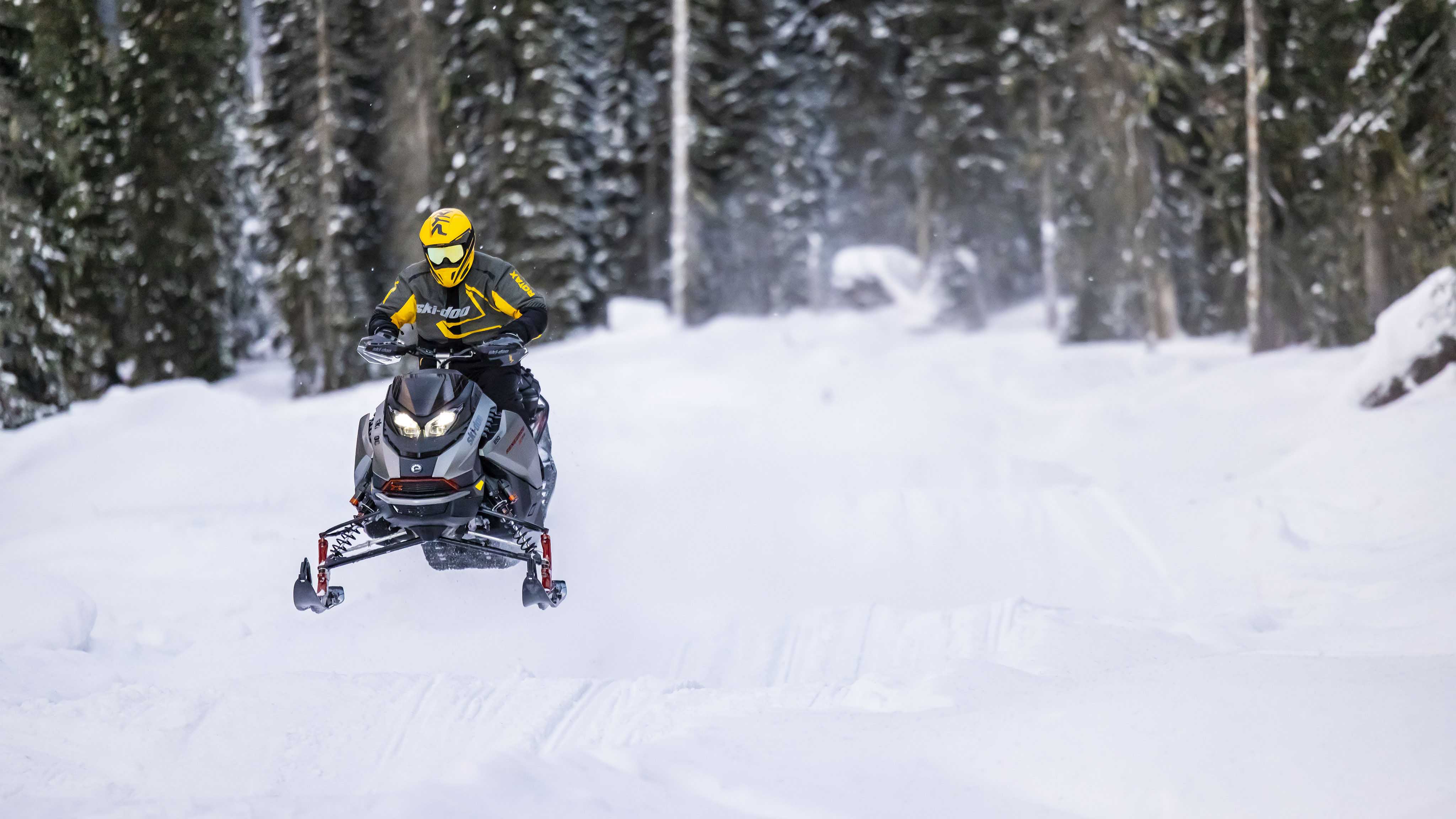 Man snowmobiling on a snowmobile trail with the 2023 Ski-Doo Renegade