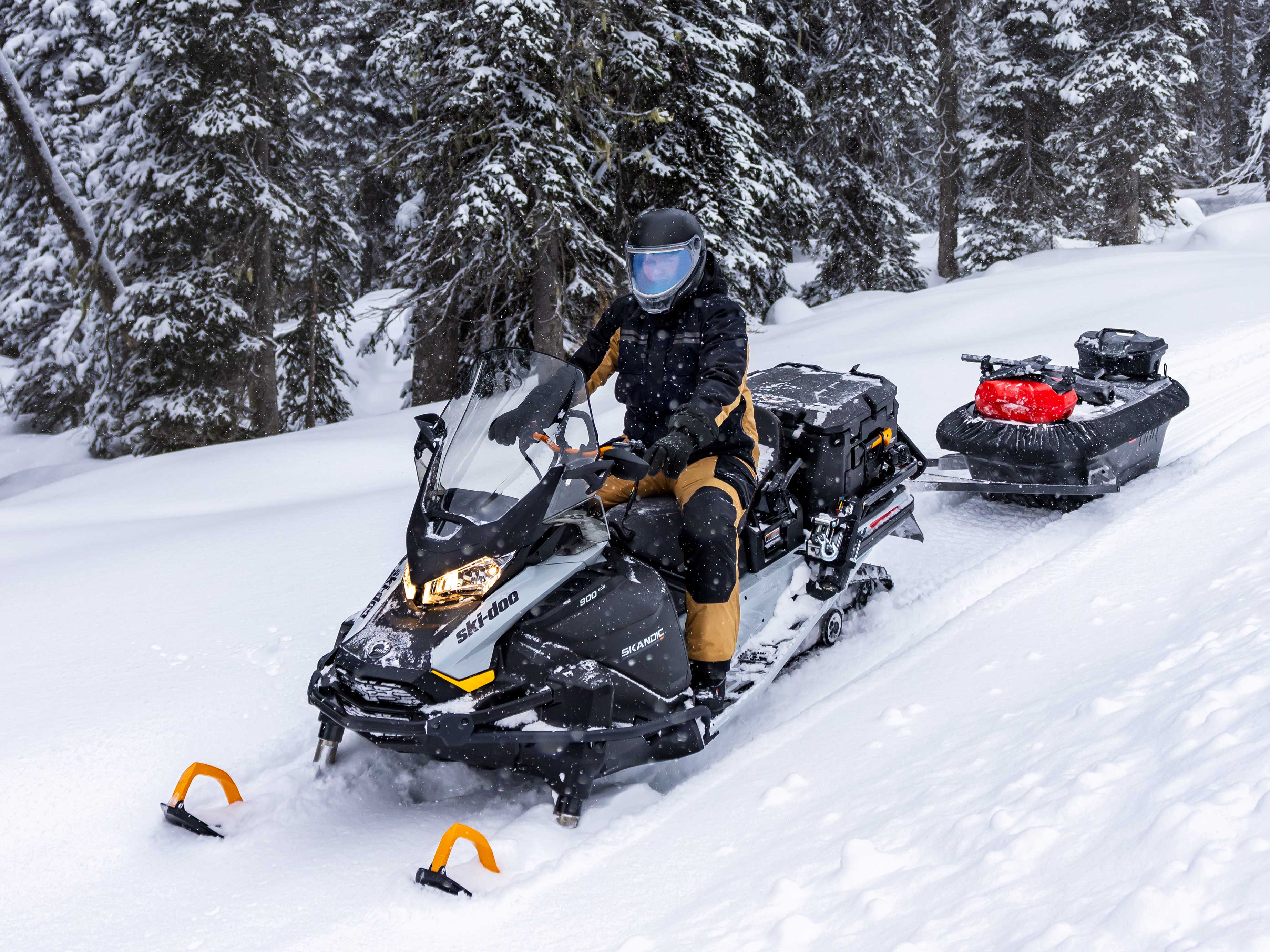 Man pulling a sled with the 2023 Ski-Doo Skandic