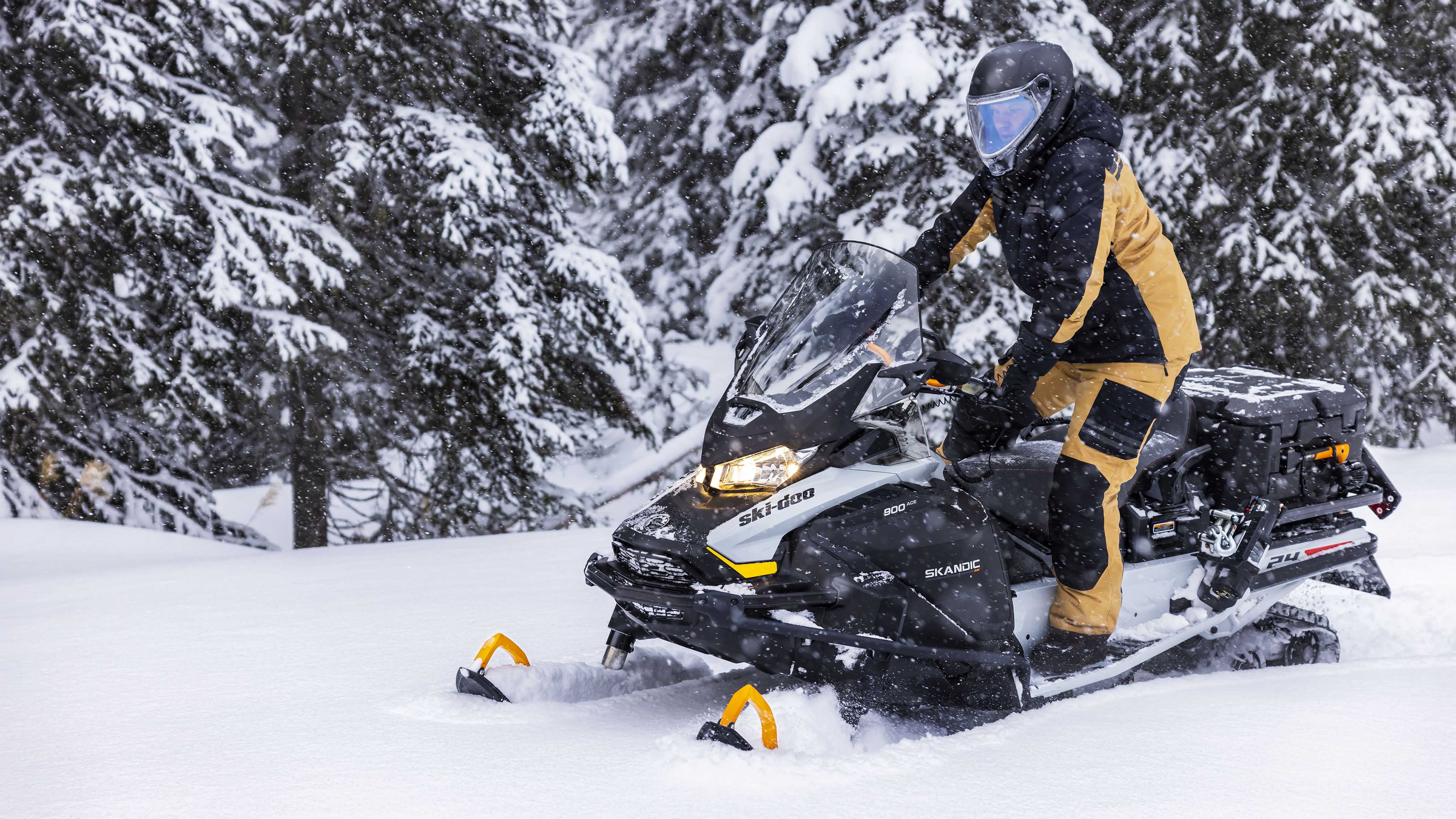 Muž stojaci na svojom skútri Ski-Doo Skandic model 2023