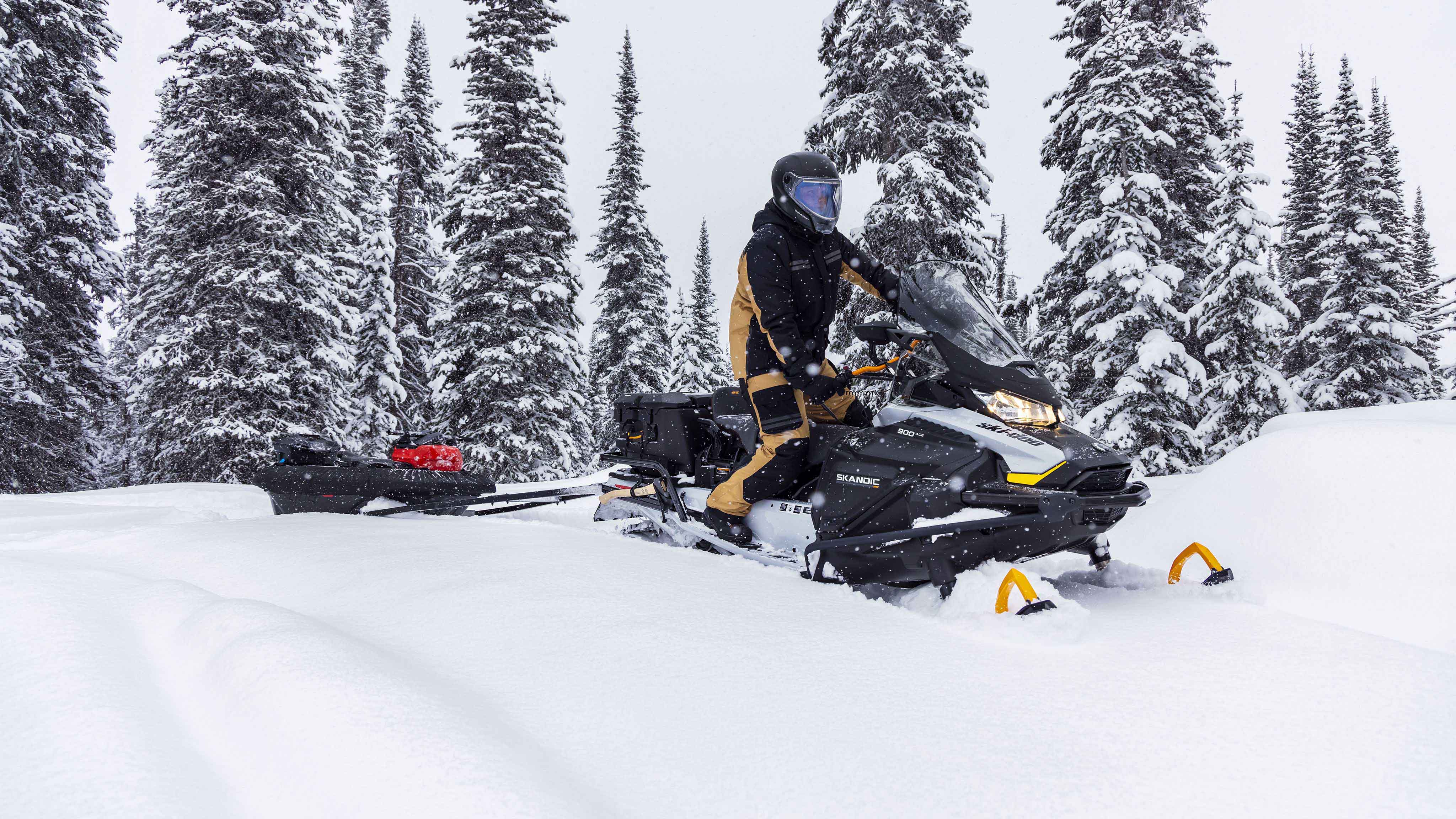 Man pulling a sled with his 2023 Ski-Doo Skandic