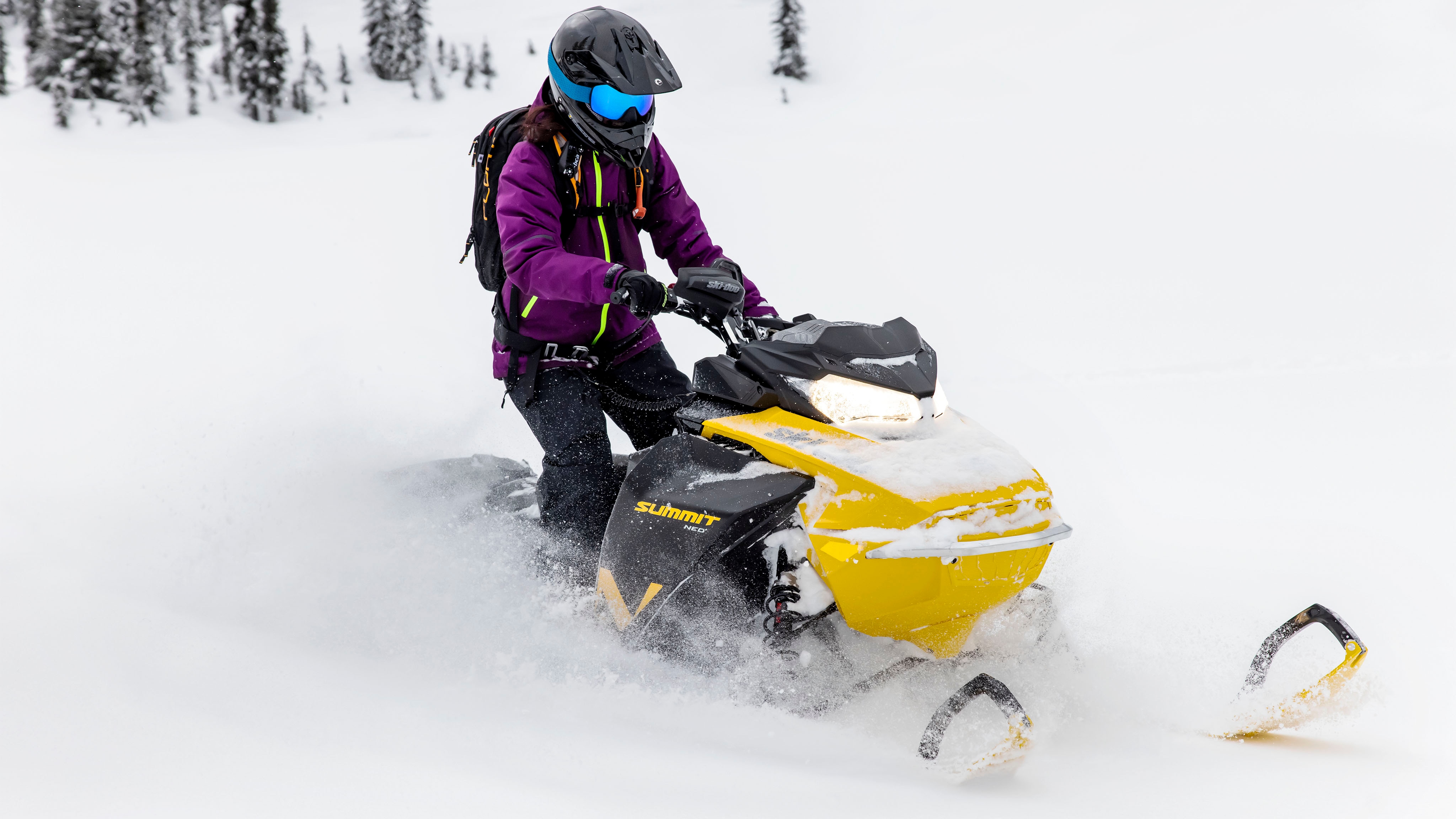 Woman in Deep-Snow with the new snowmobile Ski-Doo Summit Neo