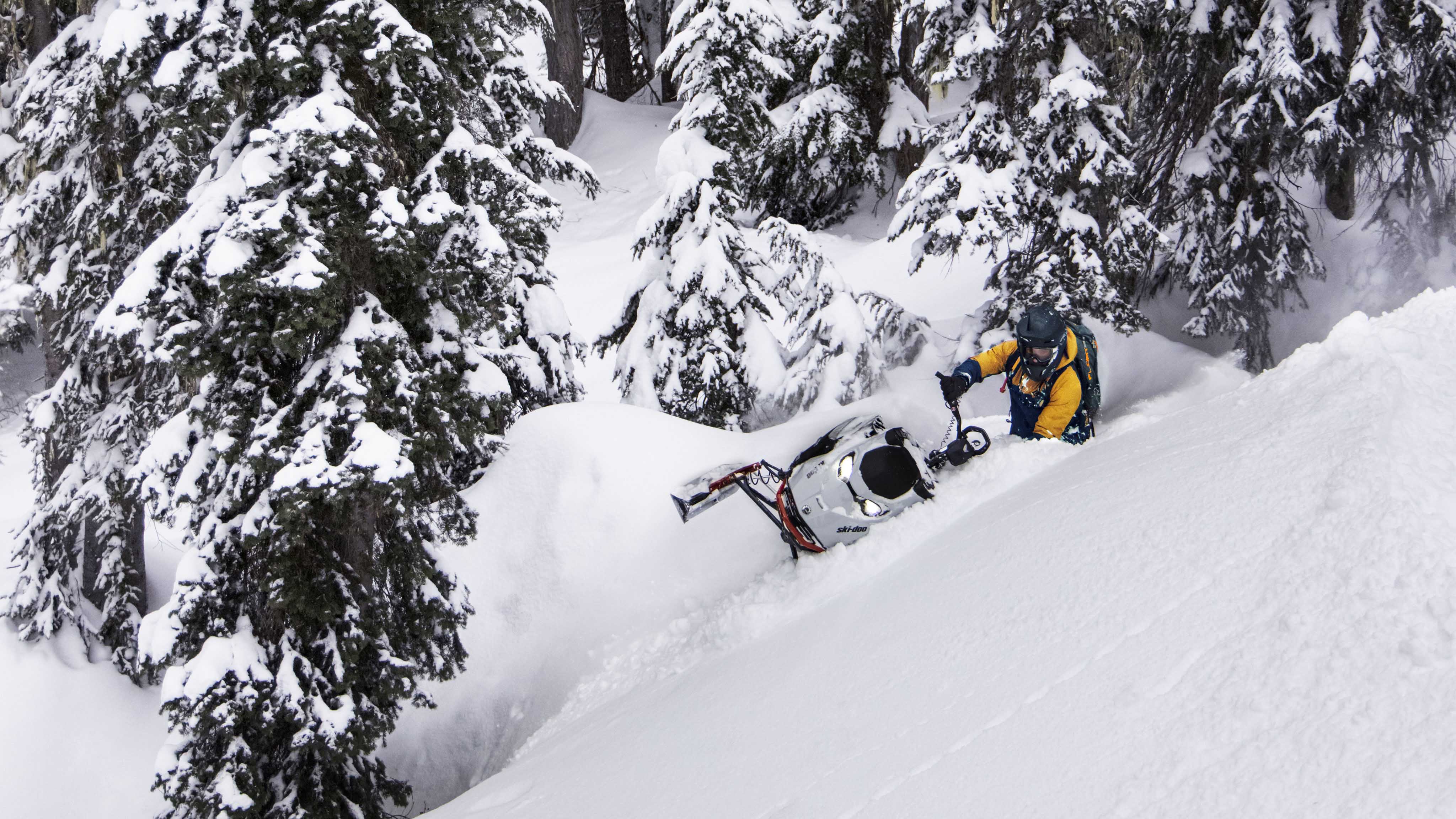 Muž v hlbokom snehu s novým skútrom Ski-Doo Summit model 2023