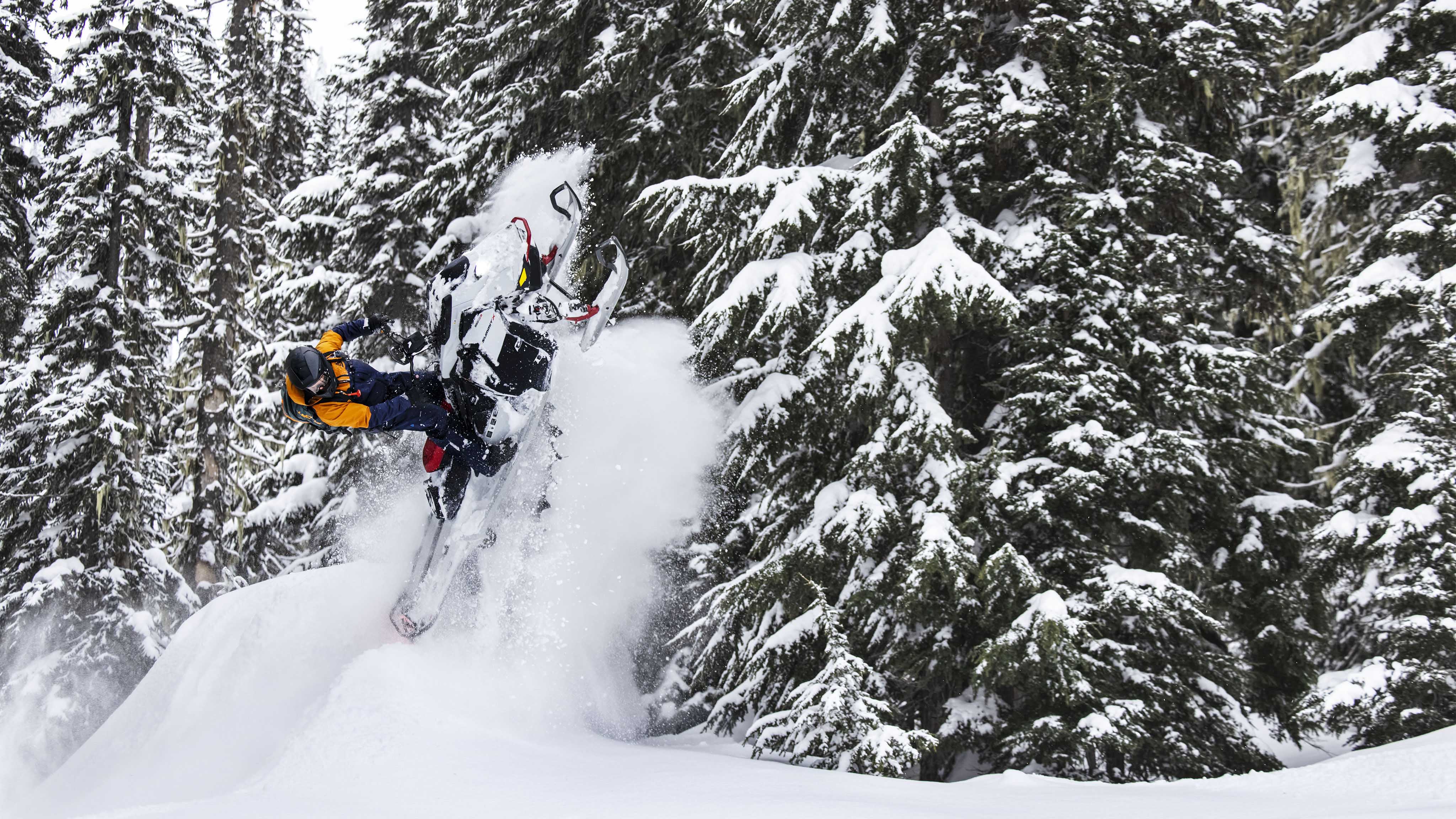 Muž pri skoku so skútrom Ski-Doo Summit model 2023