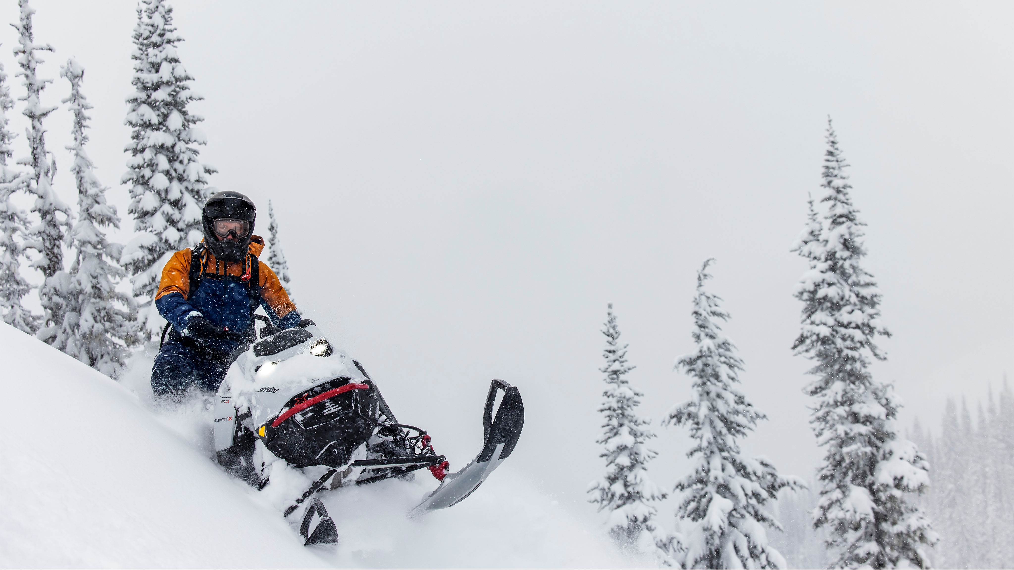 Muž počas jazdy v teréne na snežnom skútri Ski-Doo Summit model 2023