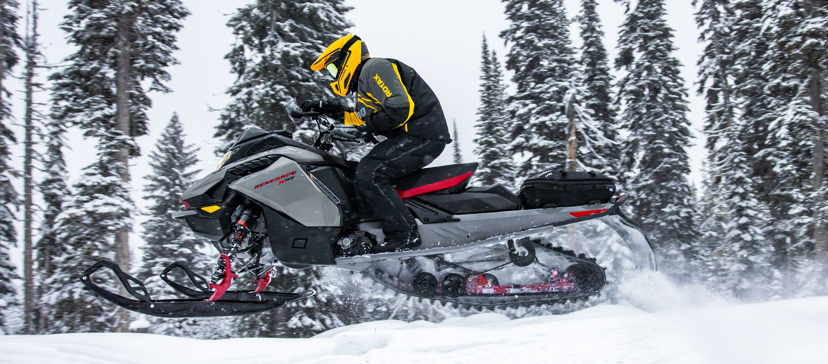 Man driving the Ski-Doo Renegade snowmobile on a trail