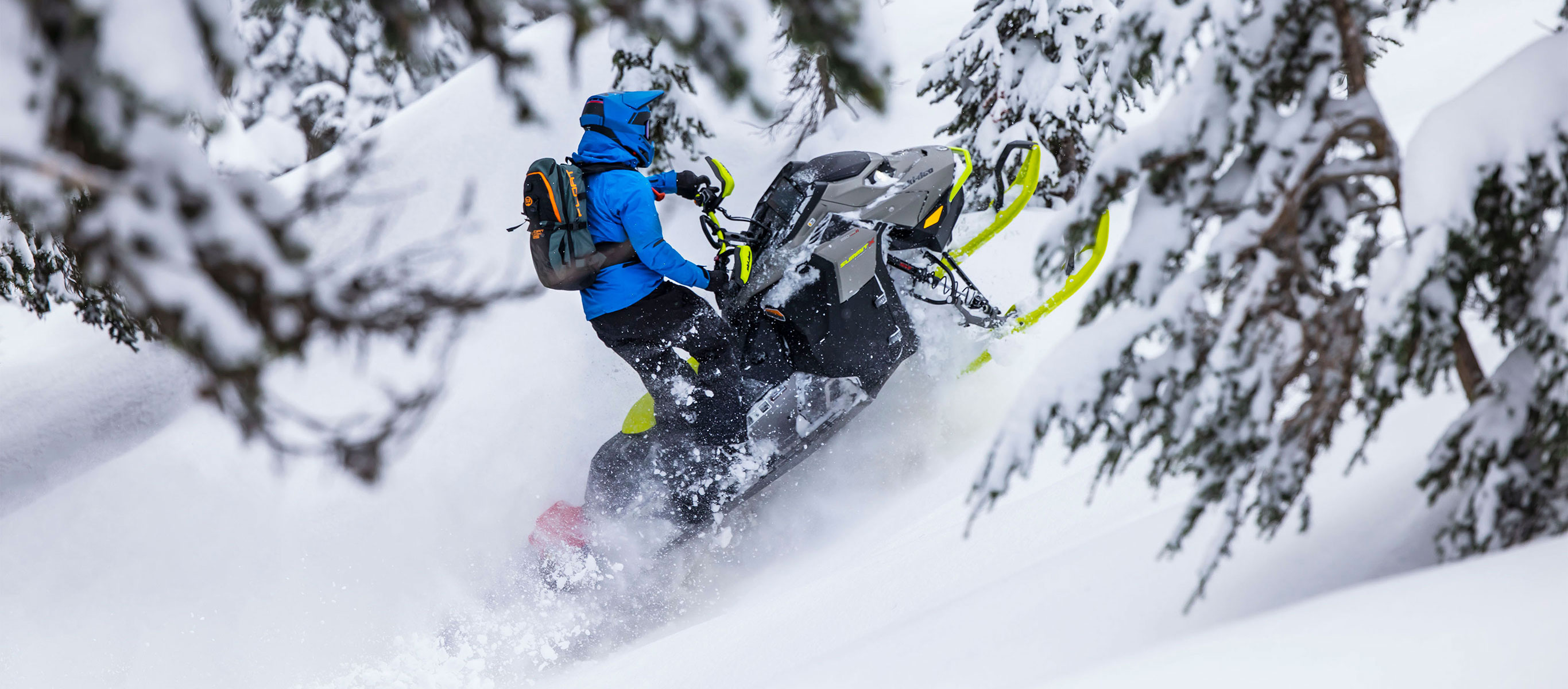 Човеч кој вози Ski-Doo моторна санка во длабочините на шумските предели.